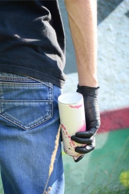 Genç mecnuna bir sprey ile standları bir beton duvara grafiti boya ile olabilir. Yasadışı vandalizm kavramı. Sokak sanatı.