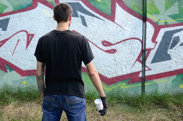 Genç mecnuna bir sprey ile standları bir beton duvara grafiti boya ile olabilir. Yasadışı vandalizm kavramı. Sokak sanatı.