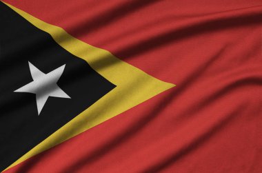 Timor Leste flag  is depicted on a sports cloth fabric with many folds. Sport team waving banner clipart
