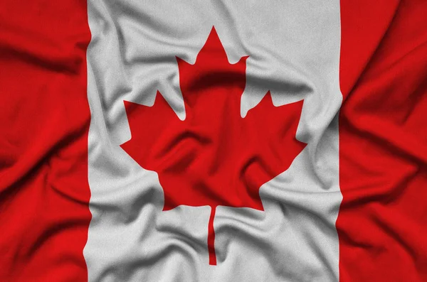 Canada flag  is depicted on a sports cloth fabric with many folds. Sport team waving banner