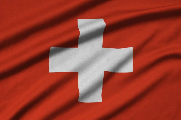 Switzerland flag  is depicted on a sports cloth fabric with many folds. Sport team waving banner