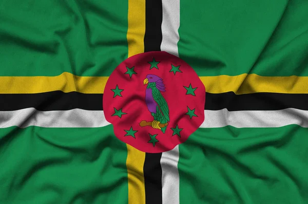 ドミニカ国の国旗は 多くのひだを持つスポーツの布生地に描かれています スポーツ チームを振ってバナー — ストック写真