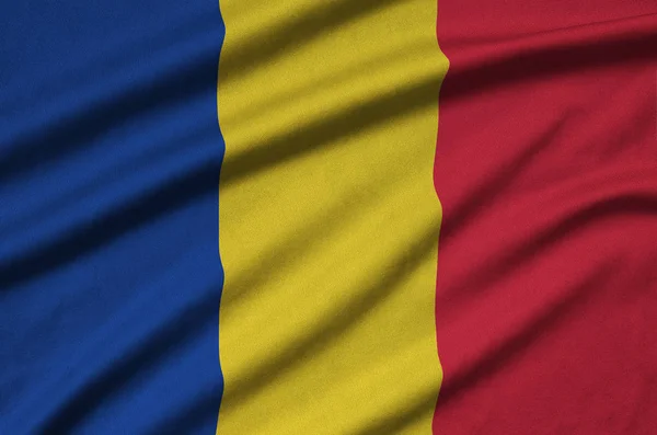 ルーマニアの国旗は 多くのひだを持つスポーツの布生地に描かれています スポーツ チームを振ってバナー — ストック写真