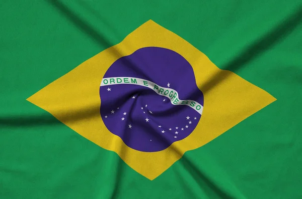 ブラジルの国旗は 多くのひだを持つスポーツの布生地に描かれています スポーツ チームを振ってバナー — ストック写真