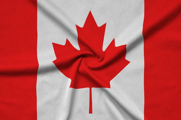 Canada flag  is depicted on a sports cloth fabric with many folds. Sport team waving banner