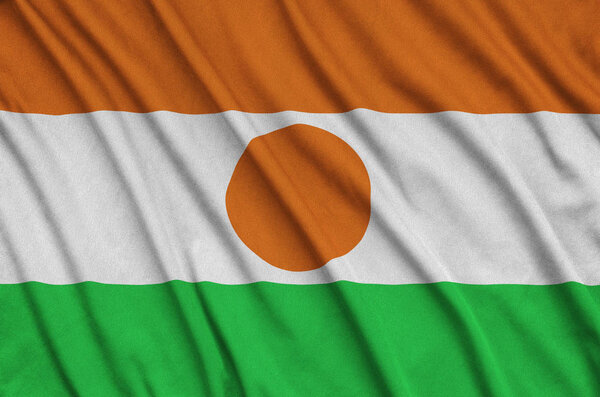 Niger flag  is depicted on a sports cloth fabric with many folds. Sport team waving banner