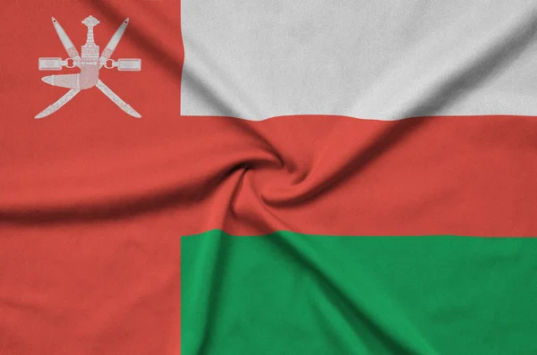 Oman flag  is depicted on a sports cloth fabric with many folds. Sport team waving banner
