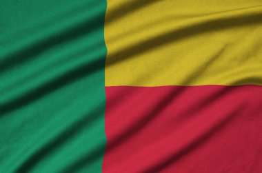 Benin flag  is depicted on a sports cloth fabric with many folds. Sport team waving banner