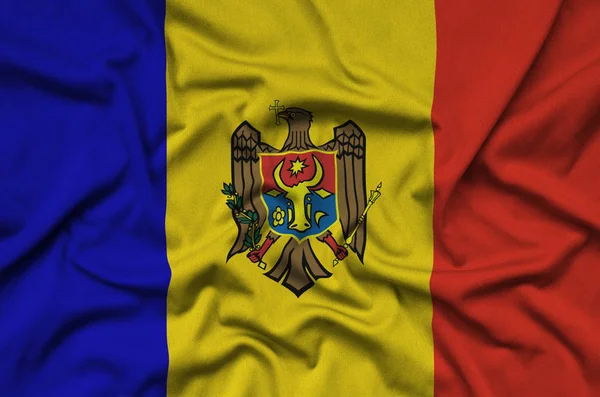 Moldova flag  is depicted on a sports cloth fabric with many folds. Sport team waving banner