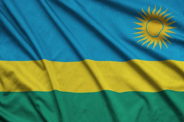 卢旺达国旗描绘在一个运动布织物与许多褶皱 运动队挥舞旗帜 — 图库照片