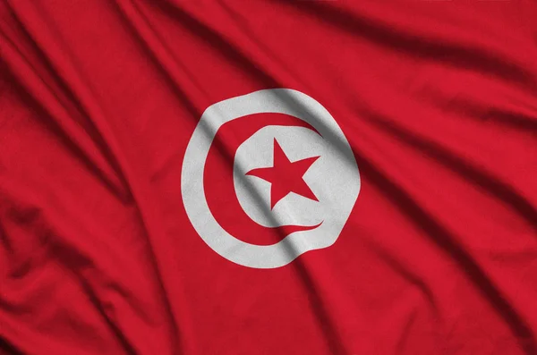 Tunisia flag  is depicted on a sports cloth fabric with many folds. Sport team waving banner