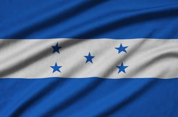ホンジュラスの国旗は 多くのひだを持つスポーツの布生地に描かれています スポーツ チームを振ってバナー — ストック写真