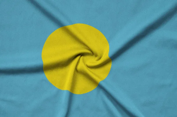 Palau flag  is depicted on a sports cloth fabric with many folds. Sport team waving banner