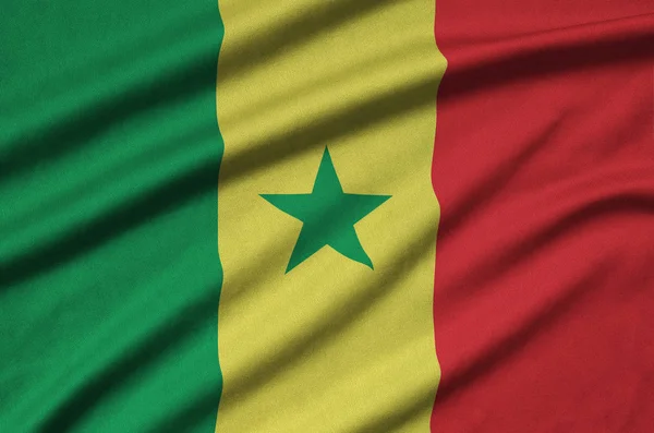 Senegal flag  is depicted on a sports cloth fabric with many folds. Sport team waving banner
