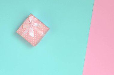 Küçük pembe hediye kutusu yalan üzerine doku arka planını moda pastel mavi ve pembe renk kağıt en az kavramında.