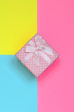 Küçük pembe hediye kutusu yalan doku arka planını moda pastel mavi, sarı ve pembe kağıt en az renkleri konsept üzerine.