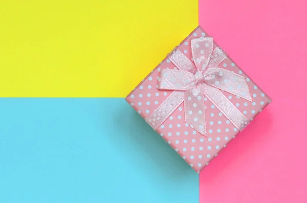 粉红色的小礼品盒躺在纹理背景的时尚粉彩蓝色 黄色和粉红色的颜色纸在最小的概念 — 图库照片