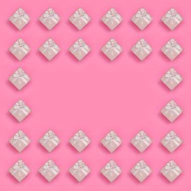 Pembe hediye kutuları çerçevesinde moda pastel pembe renkli kağıt doku arka plan üzerinde en az kavramında yatıyor. Soyut trendy desen.