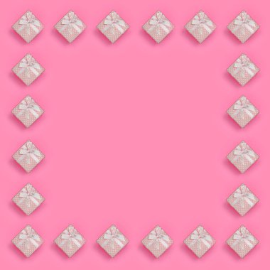 Pembe hediye kutuları çerçevesinde moda pastel pembe renkli kağıt doku arka plan üzerinde en az kavramında yatıyor. Soyut trendy desen.