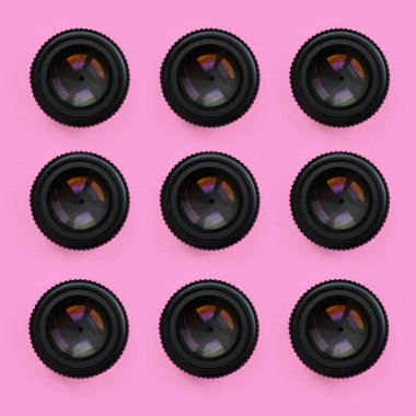 Bir kaç kamera lensler kapalı bir diyafram ile moda pastel pembe renkli kağıt doku arka plan üzerinde en az düzeyde kavram yalan. Soyut trendy desen.