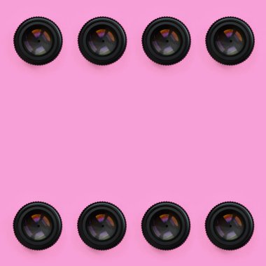 Bir kaç kamera lensler kapalı bir diyafram ile moda pastel pembe renkli kağıt doku arka plan üzerinde en az düzeyde kavram yalan. Soyut trendy desen.