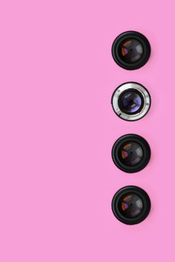 Bir kaç kamera lensler kapalı bir diyafram ile moda pastel pembe renkli kağıt doku arka plan üzerinde en az düzeyde kavram yalan. Soyut trendy desen.