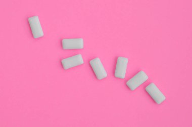 Birkaç çiğneme diş etleri moda pastel pembe renkli kağıt doku arka plan üzerinde en az düzeyde kavram yalan..