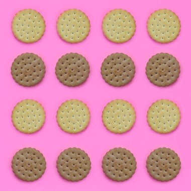 Model pembe bir arka plan üzerinde kahverengi bir bisküvi. Modaya uygun en az kavramı yemek ve tatlı. Soyut düz yatıyordu, en iyi görünümü.