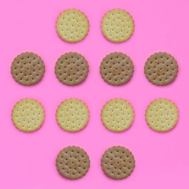 Model pembe bir arka plan üzerinde kahverengi bir bisküvi. Modaya uygun en az kavramı yemek ve tatlı. Soyut düz yatıyordu, en iyi görünümü.