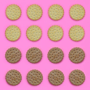 Model pembe bir arka plan üzerinde kahverengi bir bisküvi. Modaya uygun en az kavramı yemek ve tatlı. Soyut düz yatıyordu, en iyi görünümü.