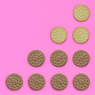 Model pembe bir arka plan üzerinde kahverengi bir bisküvi. Modaya uygun en az kavramı yemek ve tatlı. Soyut düz yatıyordu, en iyi görünümü.