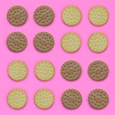 Model pembe bir arka plan üzerinde kahverengi bir bisküvi. Modaya uygun en az kavramı yemek ve tatlı. Soyut düz yatıyordu, en iyi görünümü.