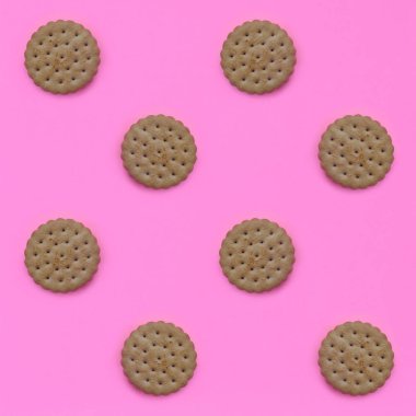 Model pembe bir arka plan üzerinde kahverengi bir bisküvi. Modaya uygun en az kavramı yemek ve tatlı. Soyut düz yatıyordu, en iyi görünümü.