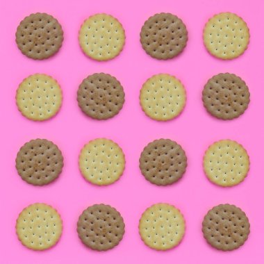 Model pembe bir arka plan üzerinde kahverengi bir bisküvi. Modaya uygun en az kavramı yemek ve tatlı. Soyut düz yatıyordu, en iyi görünümü.