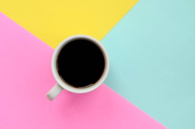 Moda pastel mavi küçük beyaz kahve fincanı doku arka planda sarı ve pembe renklerde en az kavramında kağıt..