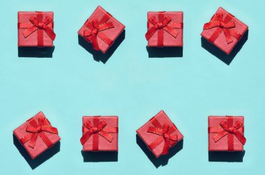 Doku arka plan üzerinde birçok küçük kırmızı pembe hediye kutuları moda trendy pastel mavi renk kağıt en az kavram. Soyut desen.