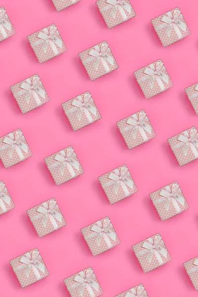 Pembe hediye kutuları bir sürü moda pastel pembe renkli kağıt doku arka plan üzerinde en az kavramında yatıyor. Soyut trendy desen.