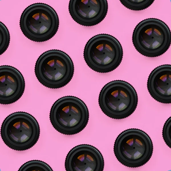 閉じた開口部でいくつかのカメラのレンズは 最小限の概念でパステル ピンク色のファッション紙のテクスチャ背景に横たわる 抽象的な流行パターン — ストック写真