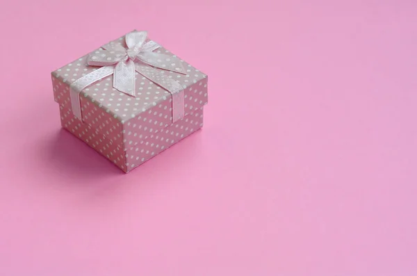 小さなピンクのギフト ボックスは パステル ピンク色のファッション紙のテクスチャ背景に最小限の概念のうそをつく — ストック写真