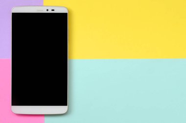 Modern smartphone ile moda pastel mavi doku arka plan üzerinde siyah perde, sarı, mor ve pembe renkler en az kavramında kağıt..
