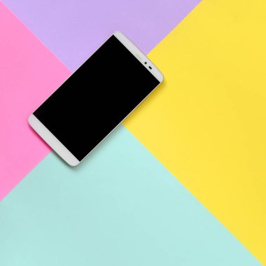 Modern smartphone ile moda pastel mavi doku arka plan üzerinde siyah perde, sarı, mor ve pembe renkler en az kavramında kağıt..