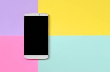 Modern smartphone ile moda pastel mavi doku arka plan üzerinde siyah perde, sarı, mor ve pembe renkler en az kavramında kağıt..
