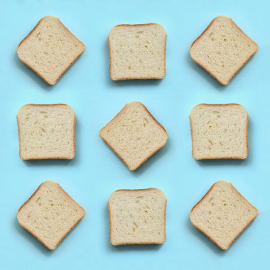 Bir kaç parça ekmek yatıyor moda pastel mavi renk kağıt doku arka plan üzerinde en az düzeyde kavram.