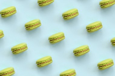 Yeşil tatlı pasta macaron veya trendy pastel mavi arka plan üstten görünüm üzerinde acıbadem kurabiyesi. Düz yatıyordu desen kompozisyonu.