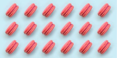 Pembe Tatlı pasta macaron veya trendy pastel mavi arka plan üstten görünüm üzerinde acıbadem kurabiyesi. Düz yatıyordu desen kompozisyonu.