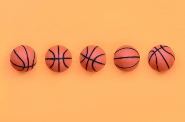 Basketbol spor oyun yalanlar üzerine en az kavramı içinde moda pastel turuncu renk kağıt doku arka plan için birçok küçük turuncu toplar.