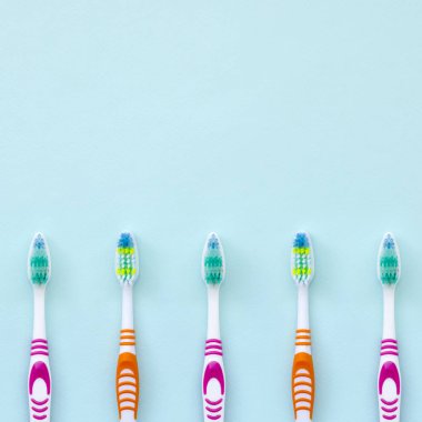 Diş fırçaları çok pastel mavi bir arka plan üzerinde yalan. Üstten görünüm, düz yatıyordu. En az kavramı.