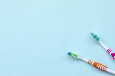 İki diş fırçaları pastel mavi bir arka plan üzerinde yalan. Üstten görünüm, düz yatıyordu. En az kavramı.