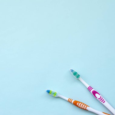 İki diş fırçaları pastel mavi bir arka plan üzerinde yalan. Üstten görünüm, düz yatıyordu. En az kavramı.