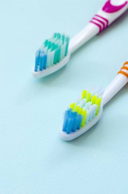 İki diş fırçaları pastel mavi bir arka plan üzerinde yalan. Üstten görünüm, düz yatıyordu. En az kavramı.